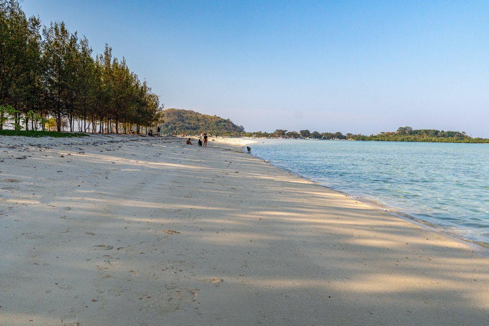 Cemara Tuban-strand: Ontspan in de schaduw van de pijnbomen aan zee.
